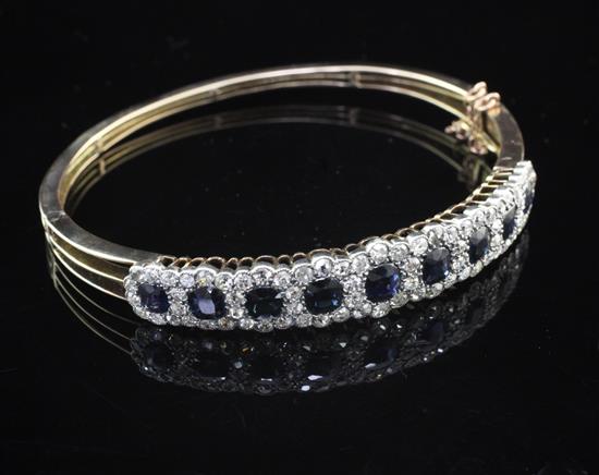 An early 20th century gold, sapphire and diamond hinged bangle,